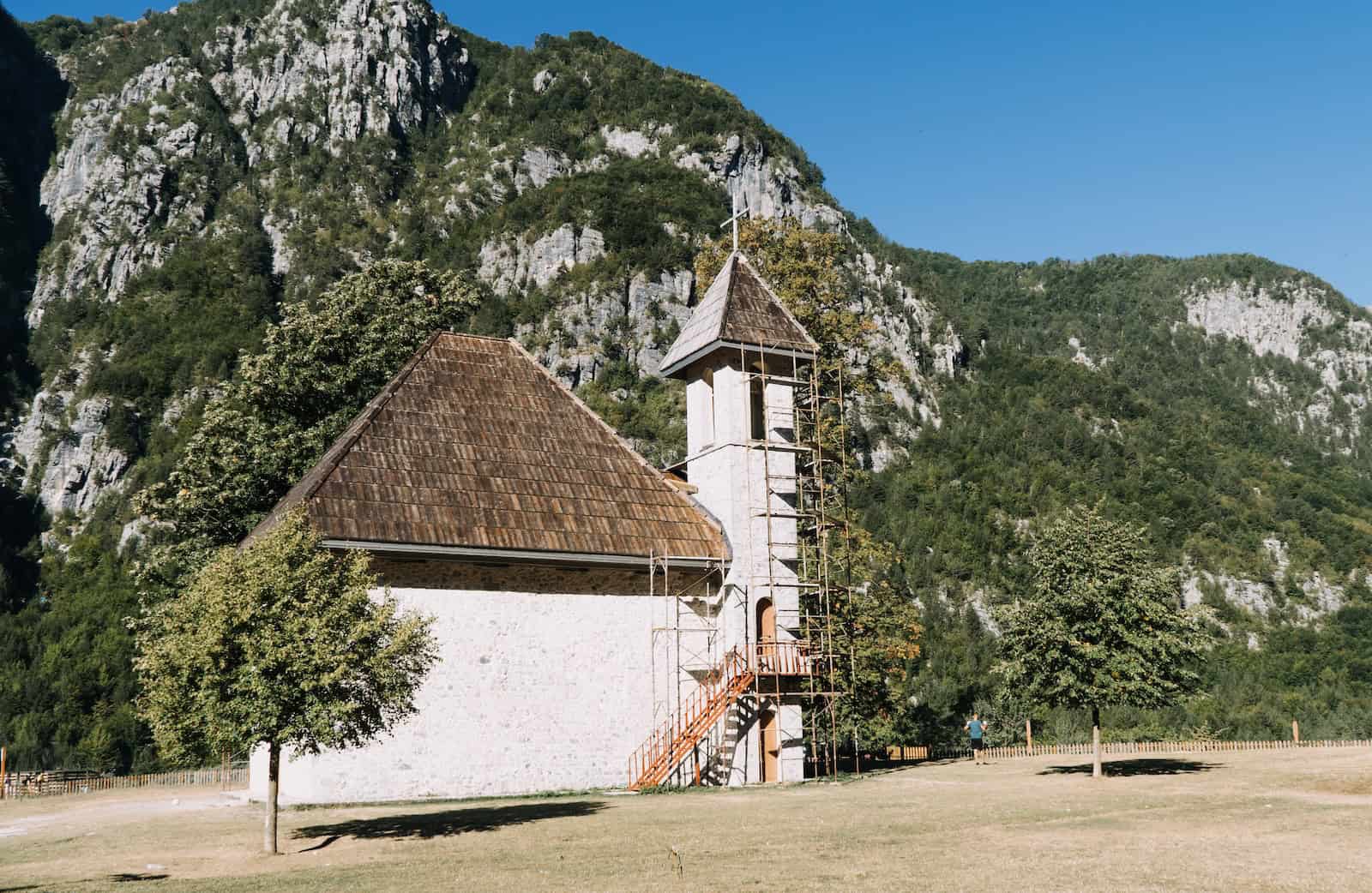 Kleine Steinkapelle in Theth vor steilen Felswänden, Start der Etappe 1