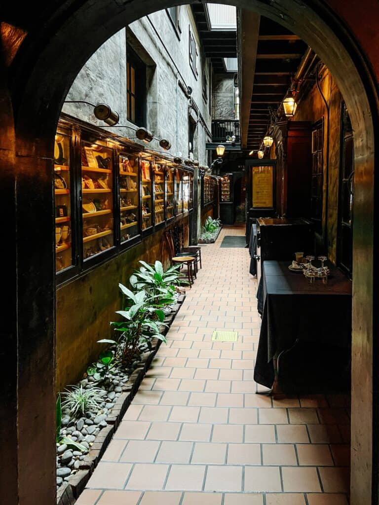 Einer der vielen Speiseräume im Restaurant Antoine's mit Regalen und Fliesenboden
